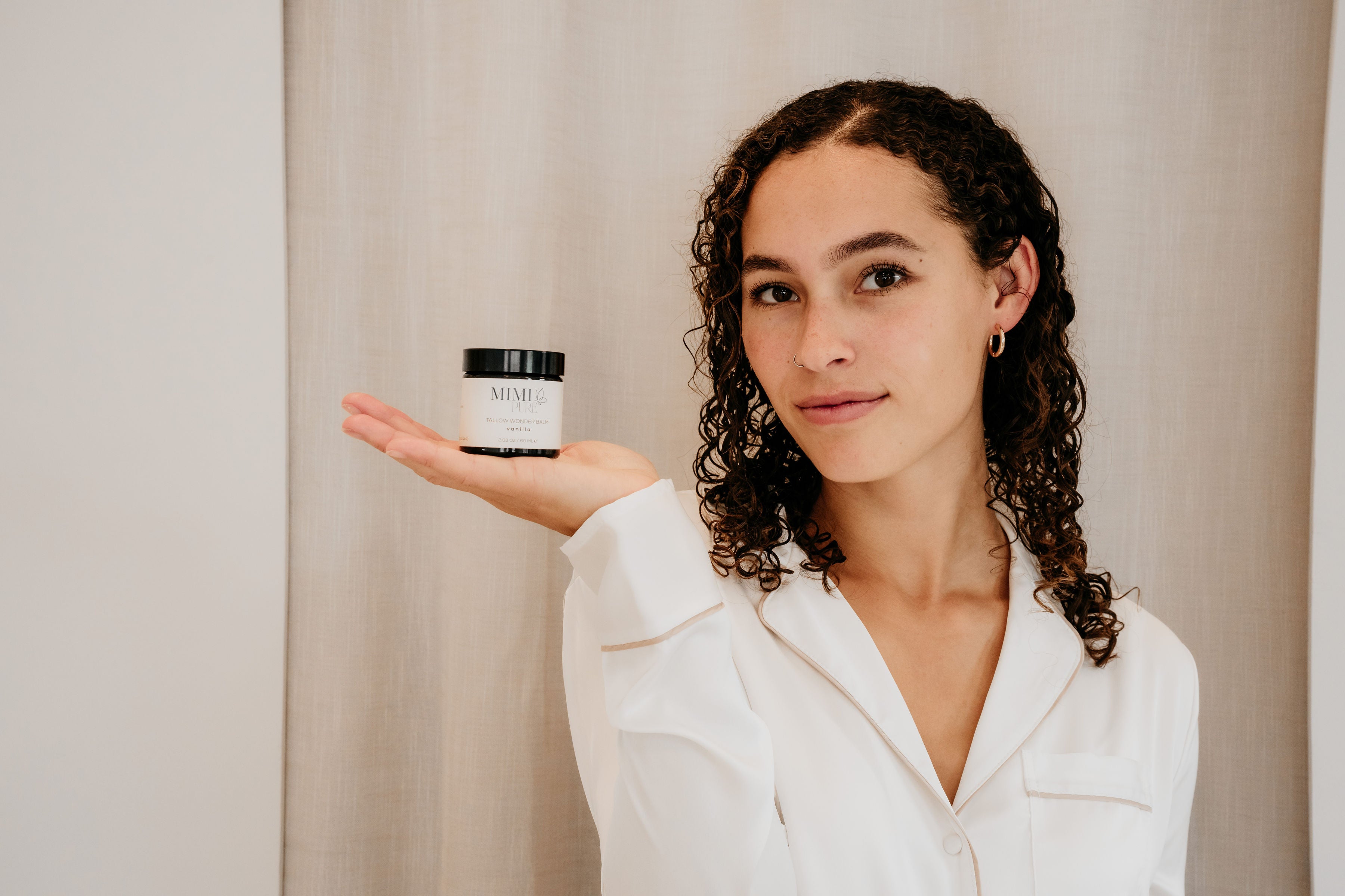 Vrouw houdt de Tallow Wonder Balm van MIMI PURE vast