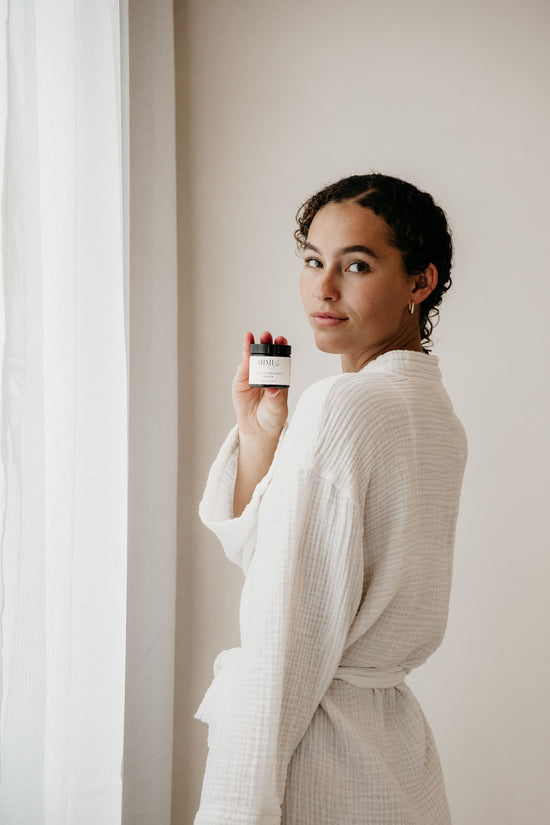 Vrouw houdt de Tallow Wonder Balm van MIMI PURE vast